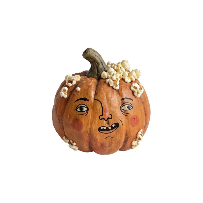 Orange pumpkin with a whimsical face and popcorn on top