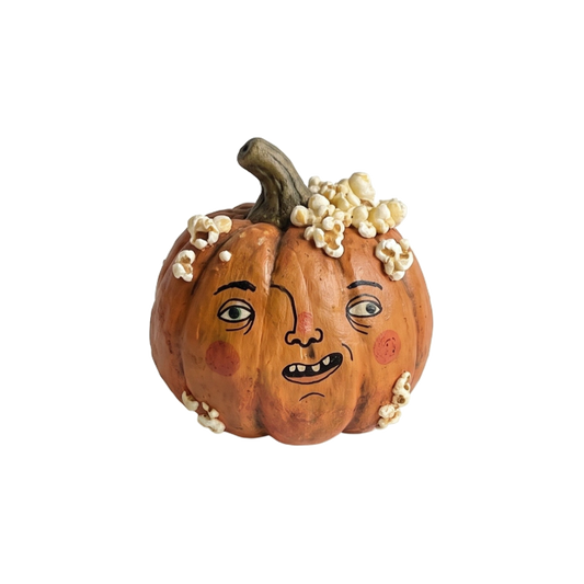 Orange pumpkin with a whimsical face and popcorn on top